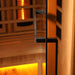 Close-up of the black finish door handle on the glass door of Golden Designs Reserve Edition 3 Person Full Spectrum Sauna with Himalayan Salt Bar, with amber light glowing inside