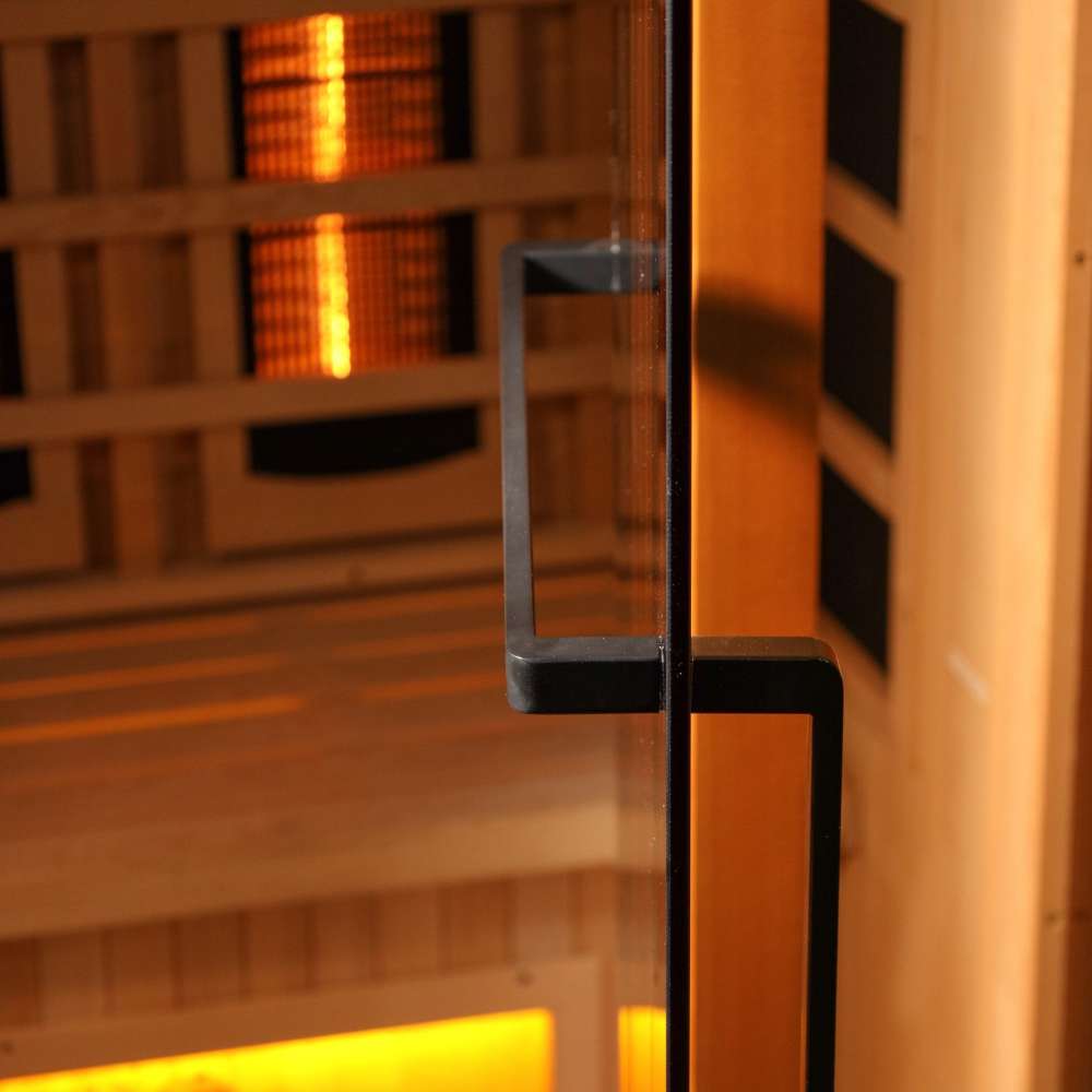 Close-up of the black finish door handle on the glass door of Golden Designs Reserve Edition 4 Person Full Spectrum Sauna with Himalayan Salt Bar, with amber light inside