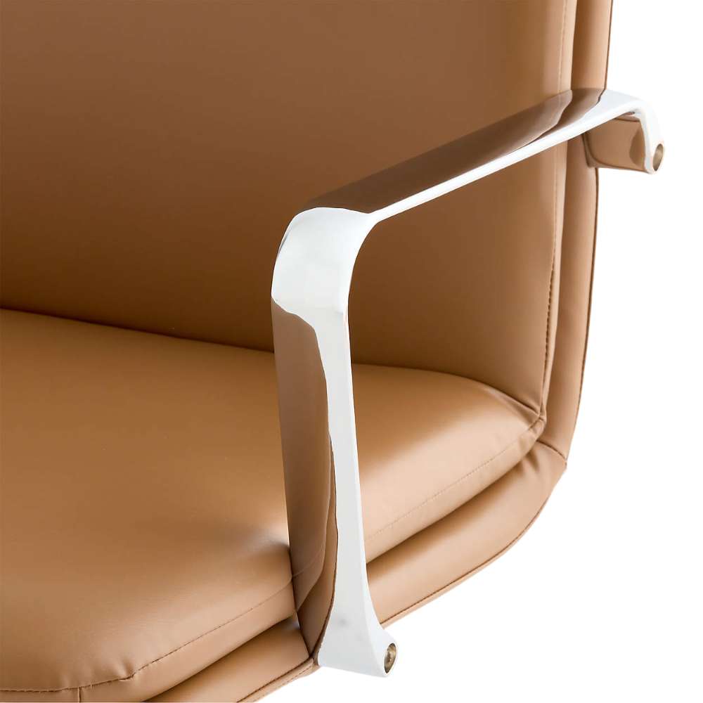 Close-up of the chrome armrest and camel faux leather seat on Crate & Barrel Smythe Camel Faux Leather Office Chair, showing the chair's sleek finish and padding