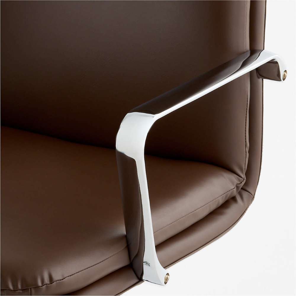 Close-up of the chrome armrest and chocolate faux leather seat on Crate & Barrel Smythe Chocolate Faux Leather Office Chair