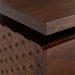 Close-up of the corner of Crate & Barrel Raffael Carved Wood Executive Desk highlighting the thick wood top and carved side detail