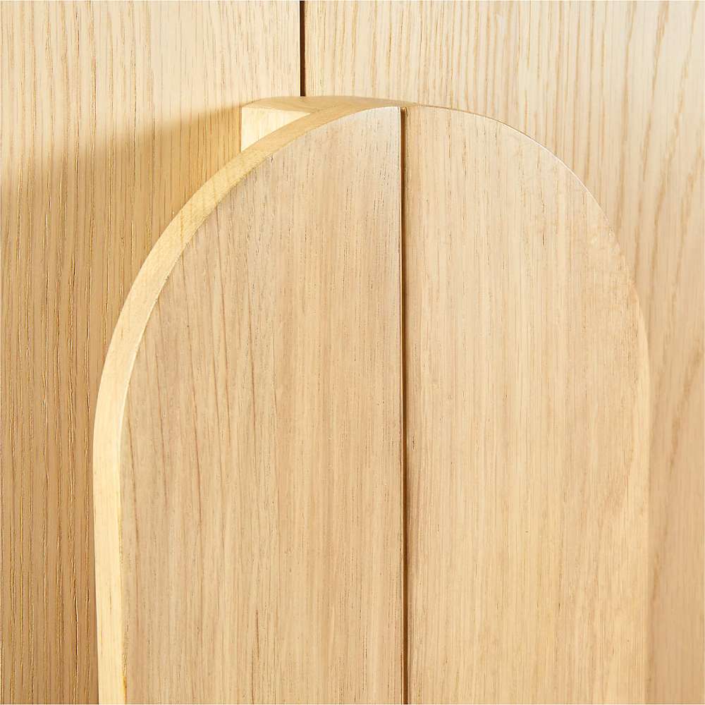 Close-up of the curved wood handle detail on the Crate & Barrel Annie 38" Natural Storage Cabinet