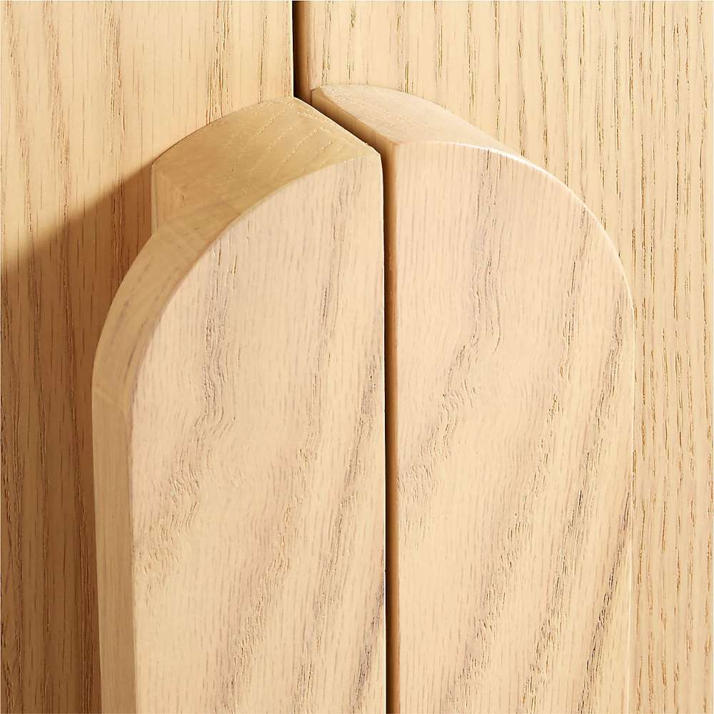 Close-up of the curved wood handles on Crate & Barrel Annie 38" Natural Wood Storage Bookcase with Shelves