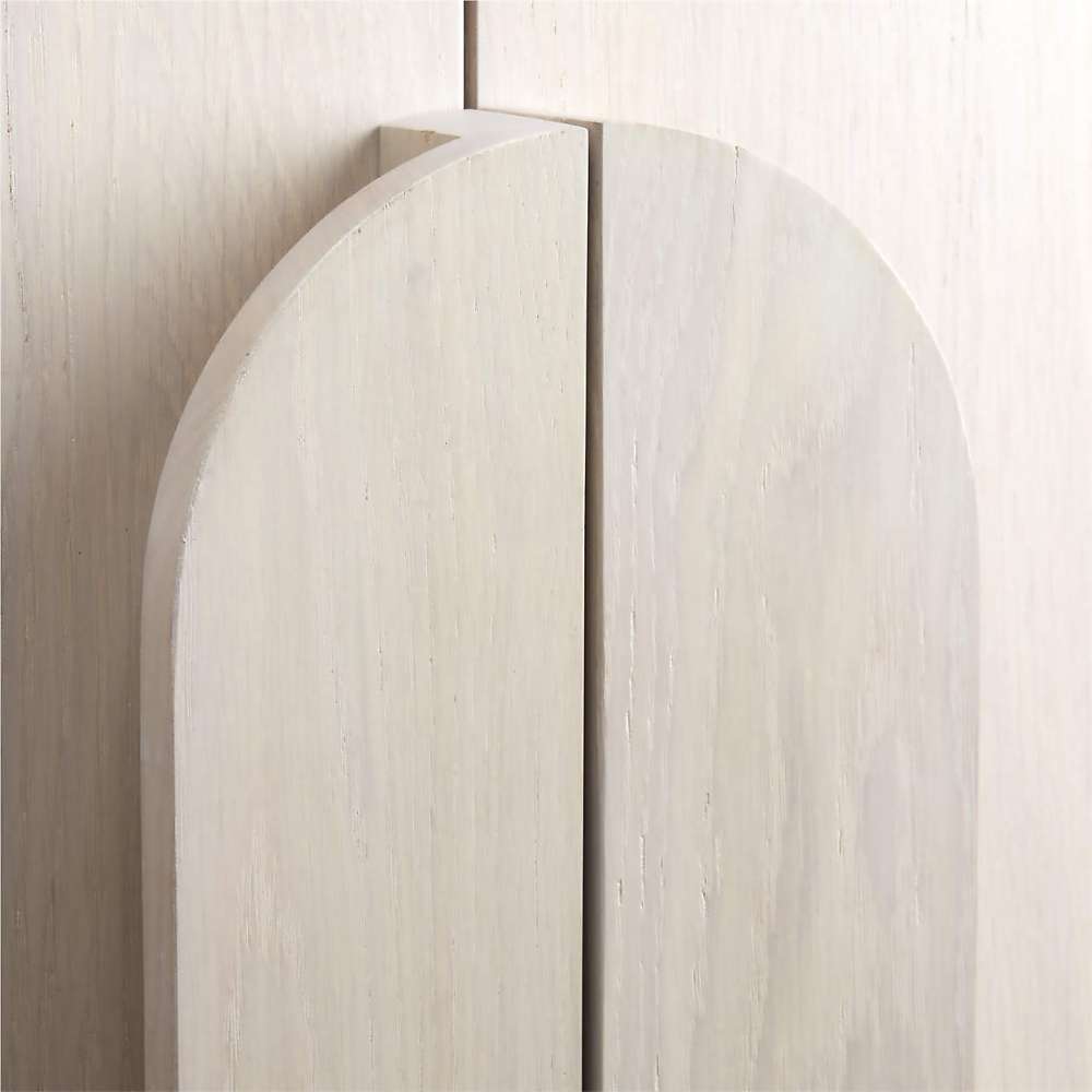 Close-up of the curved wood handles on Crate & Barrel Annie 38" Whitewash Storage Cabinet