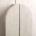 Close-up of the curved wood handles on Crate & Barrel Annie 38" Whitewash Storage Cabinet