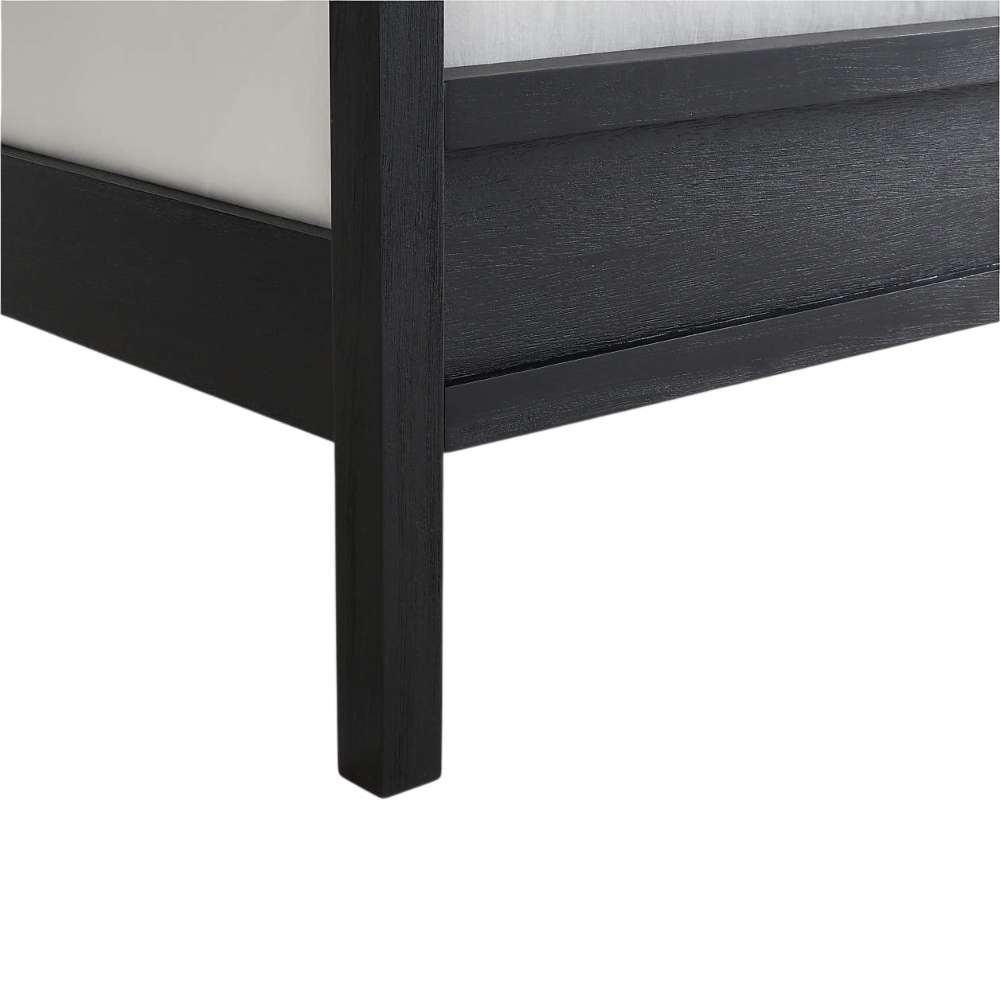 Close-up of the footboard corner on Crate & Barrel Keane Black Solid Wood Queen Canopy Bed showing the black wood finish and sturdy canopy post