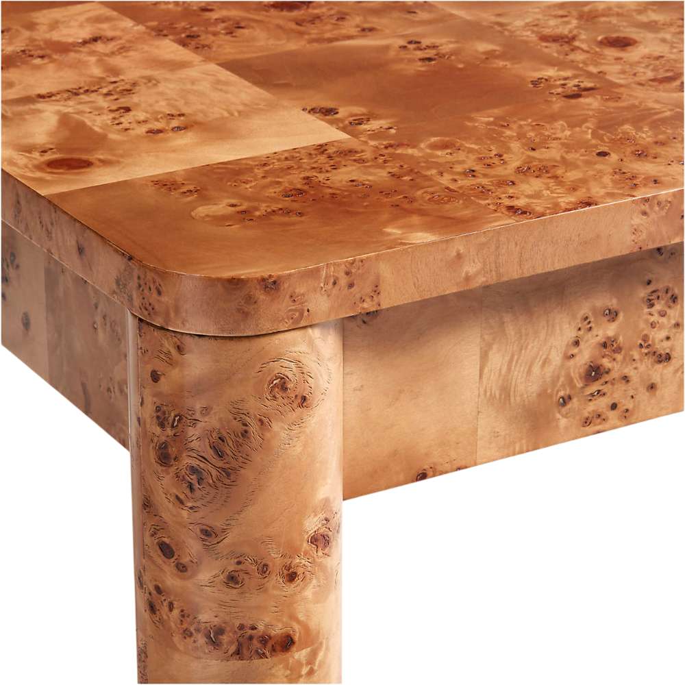 Close-up of the rounded corner and thick leg of Crate & Barrel Emerson 60" Mappa Burl Desk, showcasing the natural mappa burl wood grain