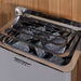 Close-up of the stainless steel stove in Golden Designs Forssa 3-4 Person Traditional Sauna with gray sauna stones resting under steel guard rails