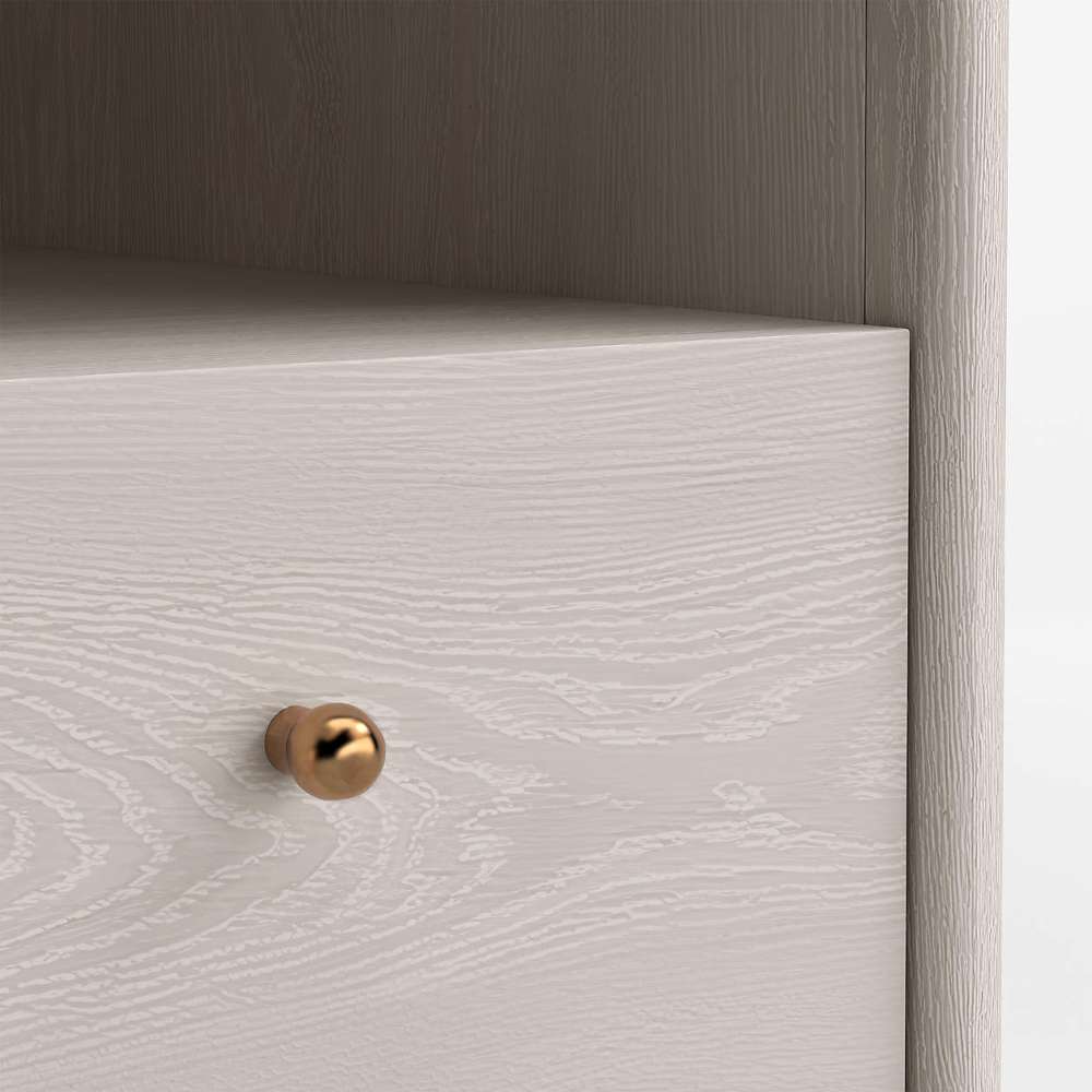 Close-up of the whitewashed wood grain and gold drawer knob on Crate & Barrel Lafayette 64" Whitewashed Desk with Outlets