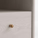 Close-up of the whitewashed wood grain and gold drawer knob on Crate & Barrel Lafayette 64" Whitewashed Desk with Outlets