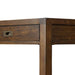 Close-up side view of Crate & Barrel Morris 48" Chocolate Brown Writing Desk showing the drawer, leg joint, and wood panel detail