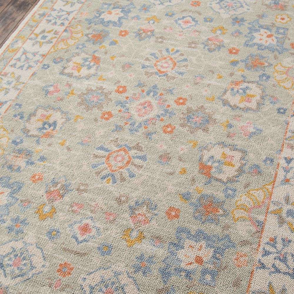 Close-up angled shot of Momeni Anatolia Indoor Rug - ANA-8 Light Blue showing intricate patterns and multi-colored floral motifs woven into the textured surface