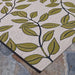 Close-up of Couristan Dolce Indoor/Outdoor Rug - Summer Ivy/Ivory-Olive shows a beige woven texture with bold olive-green leaves outlined in black