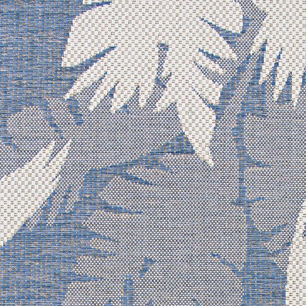 Close-up of Couristan Monaco Indoor/Outdoor Rug - Coastal Flora/Ivory-Sapphire shows large ivory leaf patterns against a sapphire background