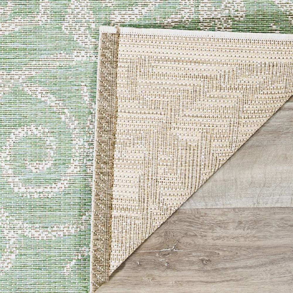 Close-up of Couristan Monaco Indoor/Outdoor Rug - Summer Quay/Ivory-Light Green shows the rug’s corner folded back