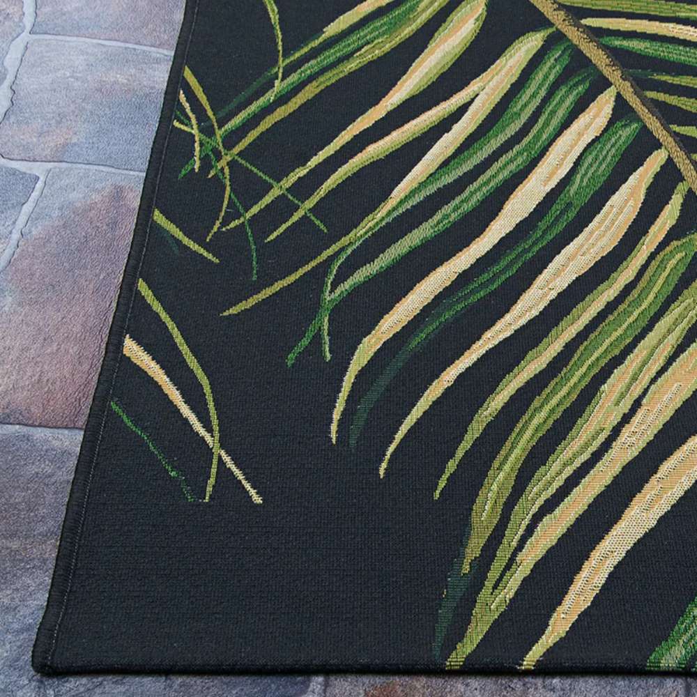 Close-up of corner of Couristan Dolce Indoor/Outdoor Rug - Bamboo Forest/Cool Onyx reveals clean stitching and a realistic palm leaf pattern