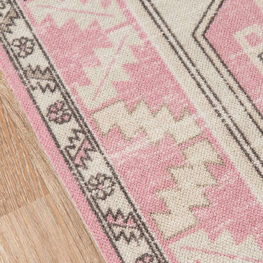 Close-up of the corner reveals the pink border and intricate motifs of Momeni Anatolia Indoor Rug - ANA-2 Pink