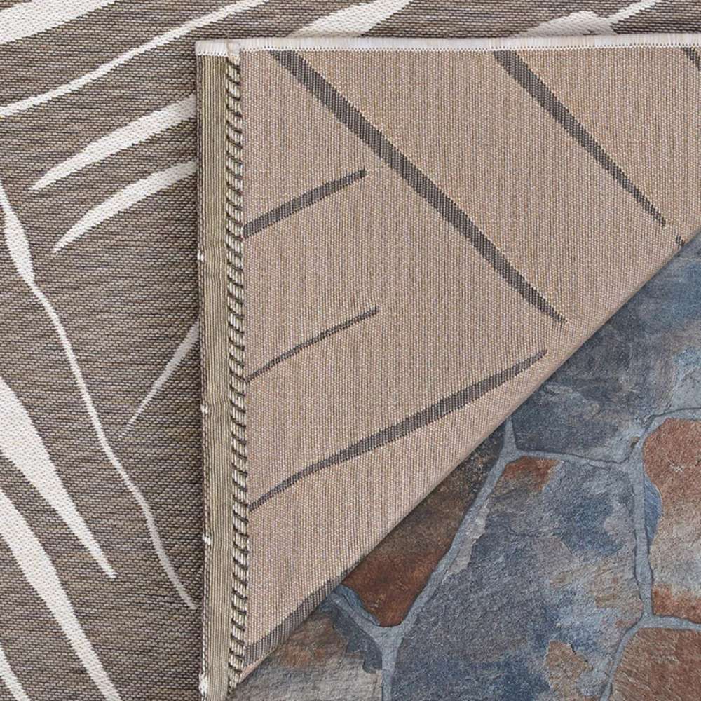 Close-up of the flipped corner of Couristan Dolce Indoor/Outdoor Rug - Parquet/Mocha shows the neat stitching and dual-tone design on the underside