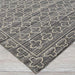 Close-up view of Couristan Fez Indoor/Outdoor Rug - Riad/Tobacco shows a textured gray background with cream geometric cross-like patterns
