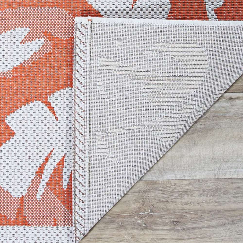 Close-up view of Couristan Monaco Indoor/Outdoor Rug - Coastal Flora/Ivory-Orange shows its reversible woven texture with ivory and orange palm leaf patterns