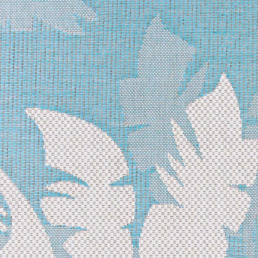 Close-up view showcases the tropical leaf design on Couristan Monaco Indoor/Outdoor Rug - Coastal Flora/Ivory-Turquoise