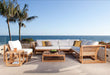 Coastal patio scene features a large outdoor sectional set that includes Westminster Teak Maya Slipper Chair, overlooking the ocean with palm trees nearby