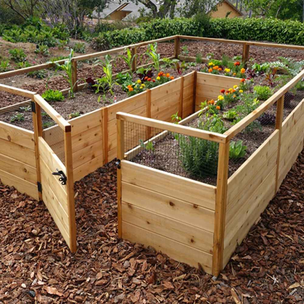 Colorful flowers and leafy vegetables grow inside an Outdoor Living Today 8×12 Raised Garden Bed with open wooden fencing and a front gate