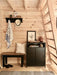 Compact entryway in the Sawmill Structures Ontario Grand Loft 107 SD Garden Room includes a black bench, wall hooks, and wood-paneled walls
