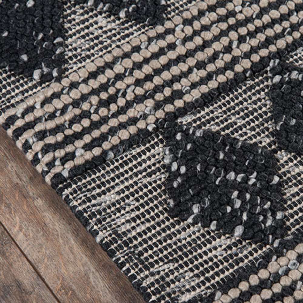 Corner detail of Momeni Andes Indoor Rug - AND-1 Charcoal highlights its sturdy weave and modern geometric pattern