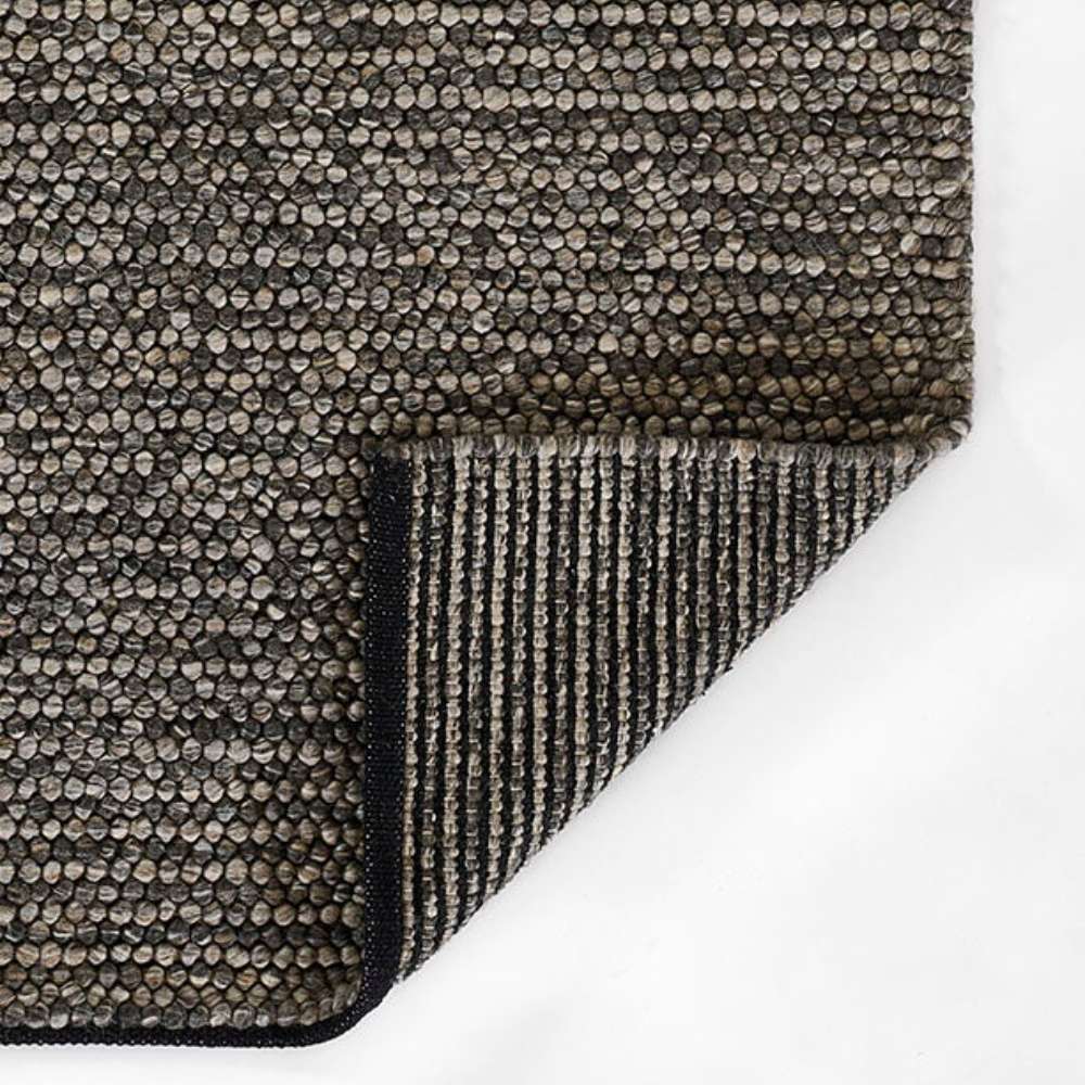 Corner fold of Momeni Andes Indoor Rug - AND-8 Charcoal reveals its durable backing and clean edging