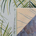 Corner of Couristan Dolce Indoor/Outdoor Rug - Bamboo Forest/Frost showing the front palm frond design and the tan-colored back texture