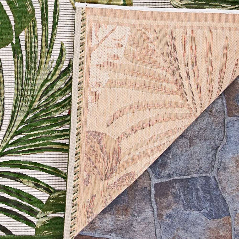 Corner of Couristan Dolce Indoor/Outdoor Rug - Flowering Fern/Ivory-Hunter Green reveals its reversible design with detailed leaf patterns on both sides