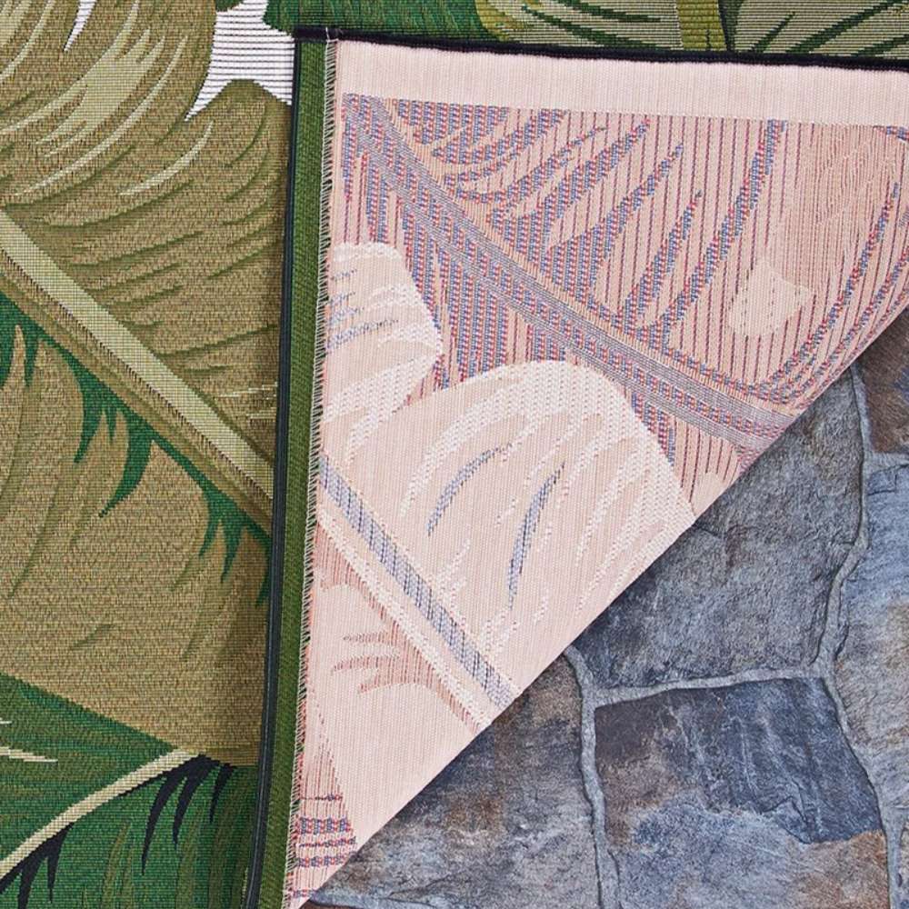 Corner of Couristan Dolce Indoor/Outdoor Rug - Palm Lily/Hunter Green-Ivory reveals its reverse side