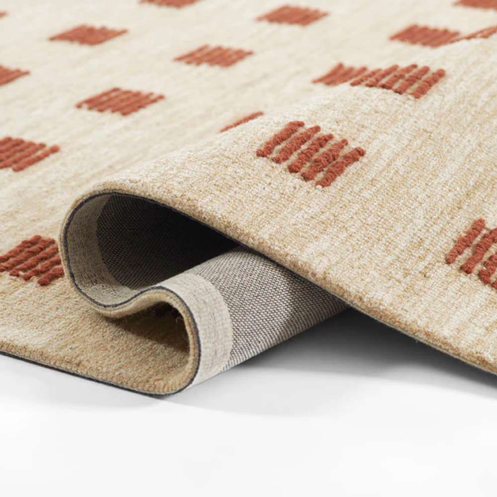 Corner of Momeni Archer Indoor Rug - ARC-1 Rust rolled slightly to reveal flexibility and backing