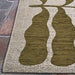 Corner of the Couristan Castille Indoor/Outdoor Rug - Fiore/Tea Leaf resting on a stone floor