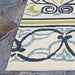 Corner of the Couristan Covington Indoor/Outdoor Rug - Pegasus/Ivory-Navy-Lime rests on slate tiles