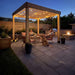 Couple and a dog relax under string lights at night with the Outdoor Living Today Western Red Cedar Urban Escape Pergola