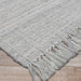 Couristan Ascot Indoor/Outdoor Rug - Windowpane/Grey is pictured from an angle, showcasing its uniform grid pattern and neatly finished fringe