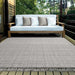 Couristan Ascot Indoor/Outdoor Rug - Windowpane/Linen is shown on a patio under a sofa, blending stylishly with the outdoor setting and natural tones