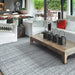Couristan Ascot Indoor/Outdoor Rug - Windowpane/Tweed lies in a stylish living room, adding soft texture and a cool tone under a rustic coffee table