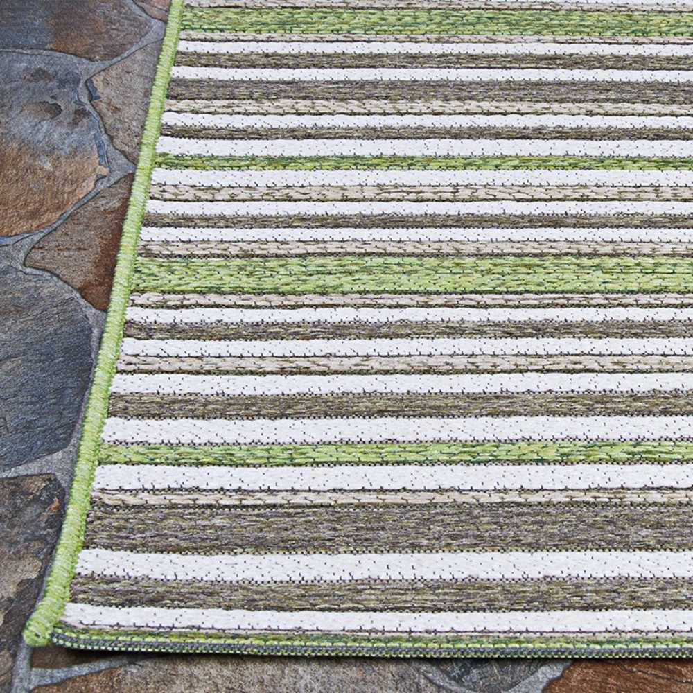 Couristan Cape Indoor/Outdoor Rug - Brockton/Hunter Green-Brown is shown laid flat on a stone patio, with neatly finished green edges