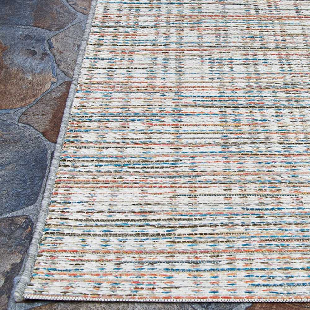 Couristan Cape Indoor/Outdoor Rug - Falmouth/Ivory-Coral is shown outdoors on a stone patio