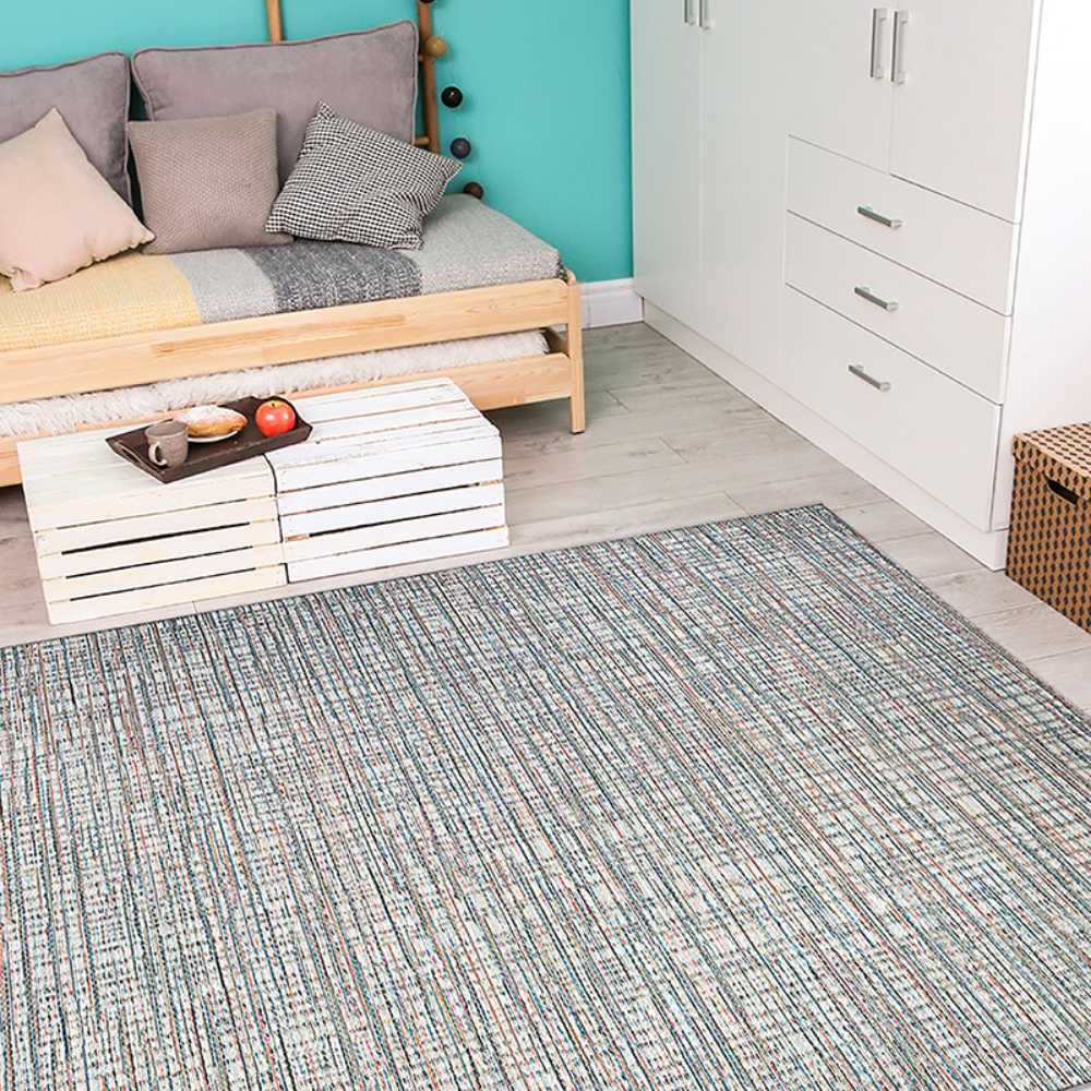Couristan Cape Indoor/Outdoor Rug - Falmouth/Ivory-Coral is spread out in a cozy bedroom, adding a colorful accent to the light wood floor and furniture