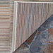 Couristan Cape Indoor/Outdoor Rug - Fayston/Multi is shown with a corner flipped to reveal its durable backing and colorful woven texture on stone flooring