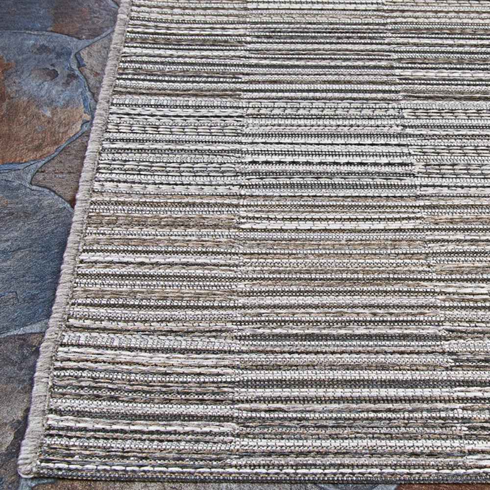 Couristan Cape Indoor/Outdoor Rug - Fayston/Silver-Charcoal is displayed flat on stone flooring, showing off its horizontal stripe pattern and neatly finished edge