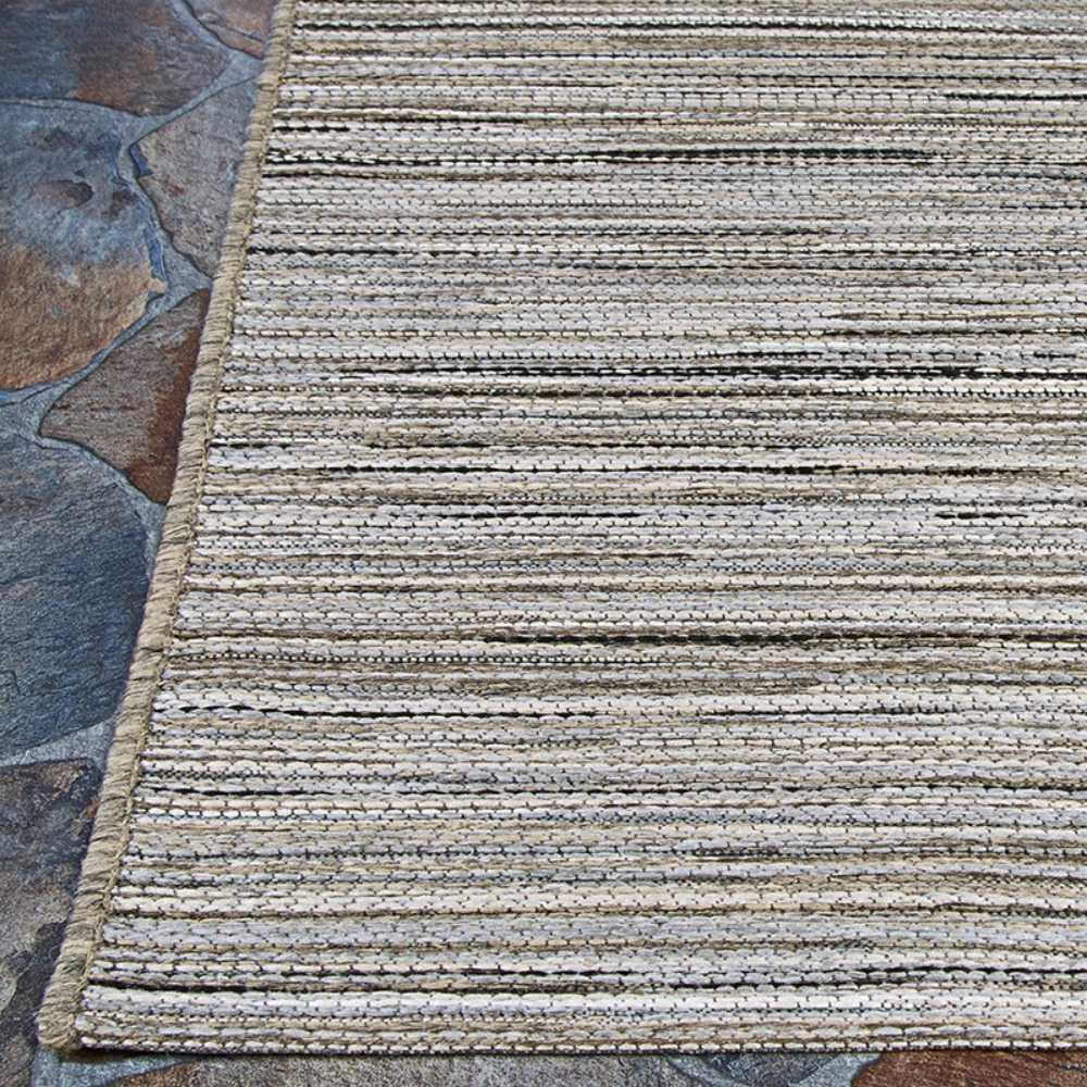 Couristan Cape Indoor/Outdoor Rug - Hinsdale/Light Brown-Silver lies flat over a stone patio