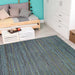 Couristan Cape Indoor/Outdoor Rug - Hinsdale/Teal-Cobalt is laid out in a bright room with a wooden daybed, white furniture, and turquoise wall