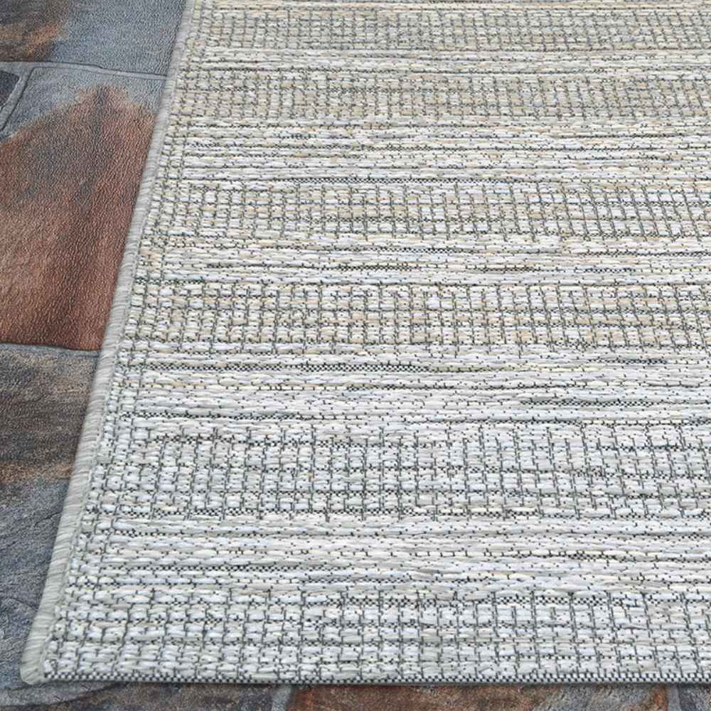 Couristan Cape Indoor/Outdoor Rug - Shallows/Taupe-Grey is shown on a stone patio