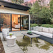 Couristan Castille Indoor/Outdoor Rug - Canvas/Tea Leaf lies stylishly under a patio seating set