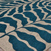 Couristan Castille Indoor/Outdoor Rug - Fiore/Petrol is shown lying flat, displaying its bold curving leaf design from a side angle